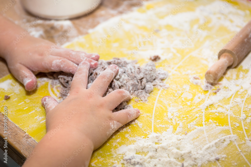 Little girl hand preparing gingerbread cookies for christmas