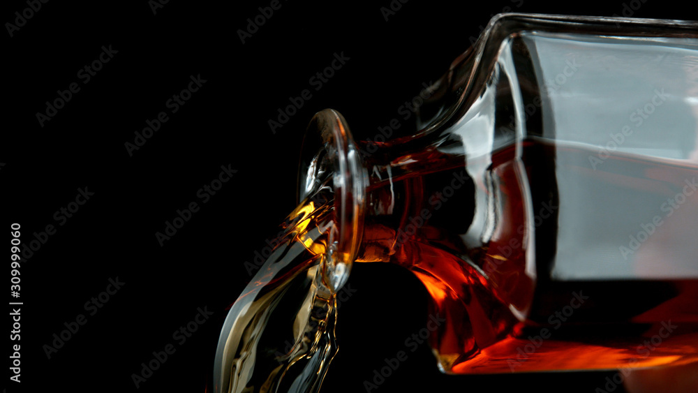 Detail of pouring whiskey from bottle