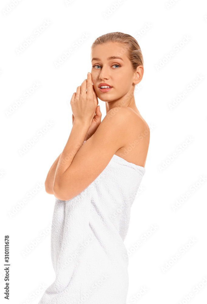 Beautiful young woman wrapped in towel on white background