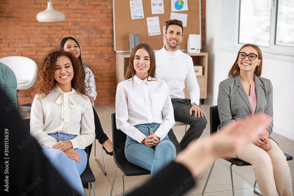 Colleagues listening to speaker at business meeting in office