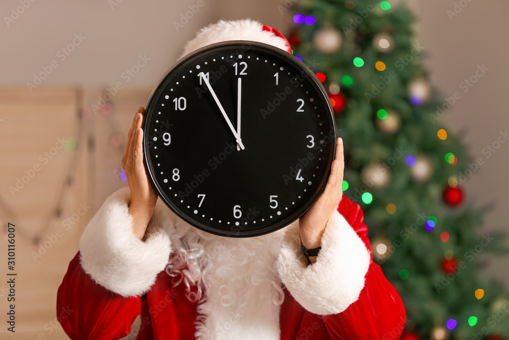 Santa Claus with clock in room. Christmas countdown concept