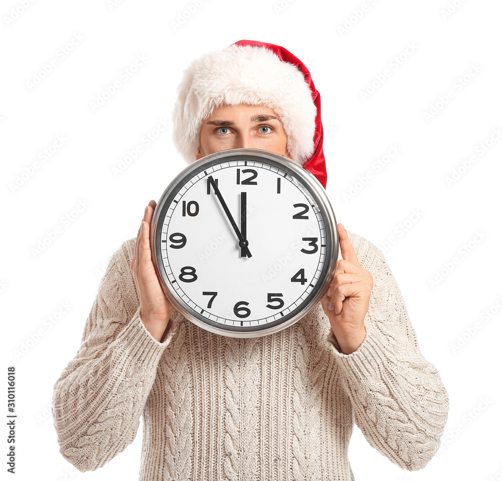 Young man in Santa hat and with clock on white background. Christmas countdown concept