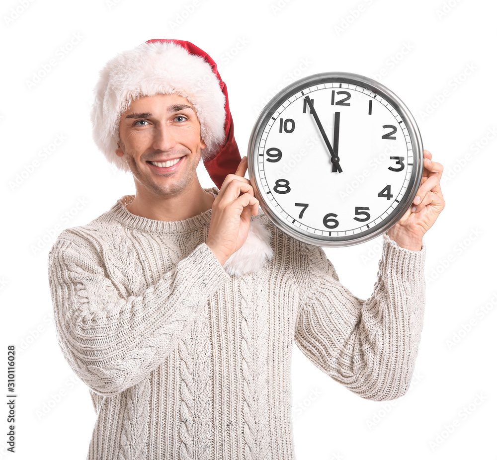 Young man in Santa hat and with clock on white background. Christmas countdown concept