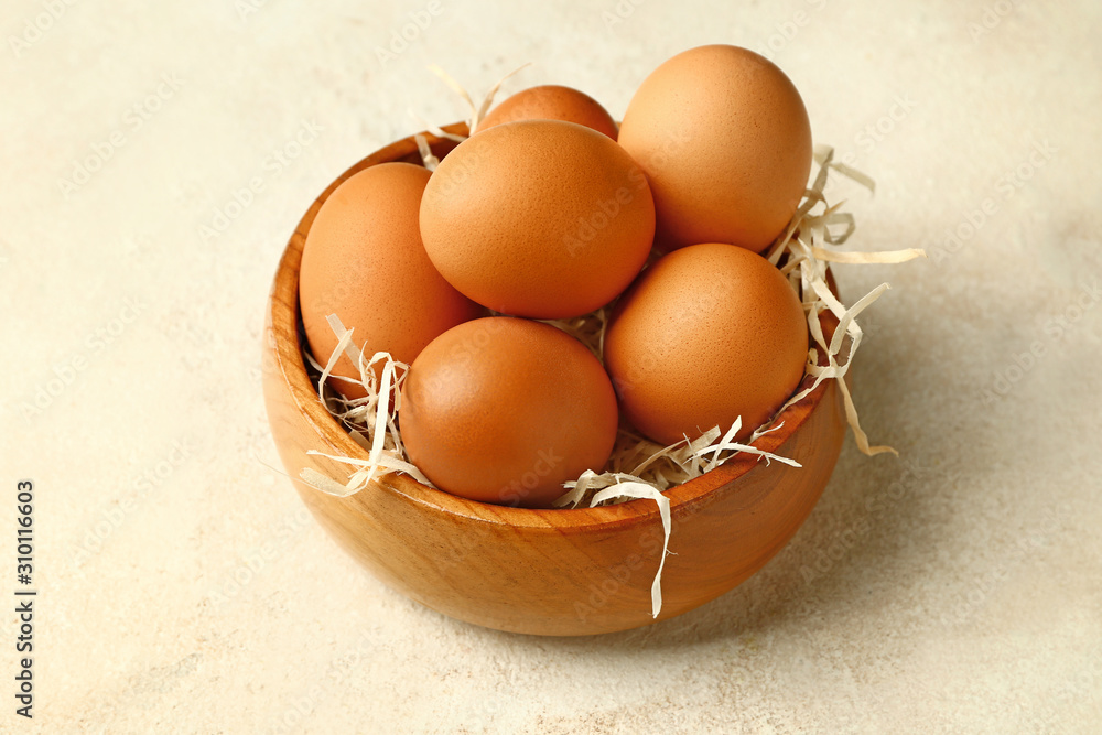 Bowl with fresh eggs on white background