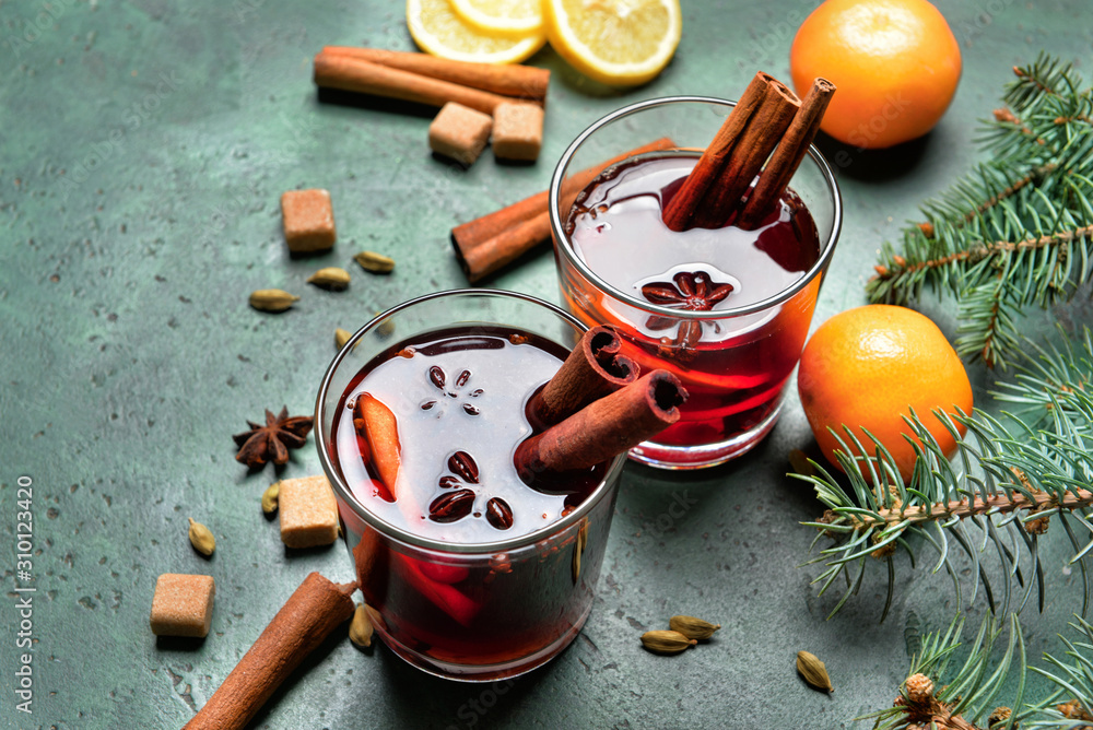 Glasses of tasty mulled wine and ingredients on color background