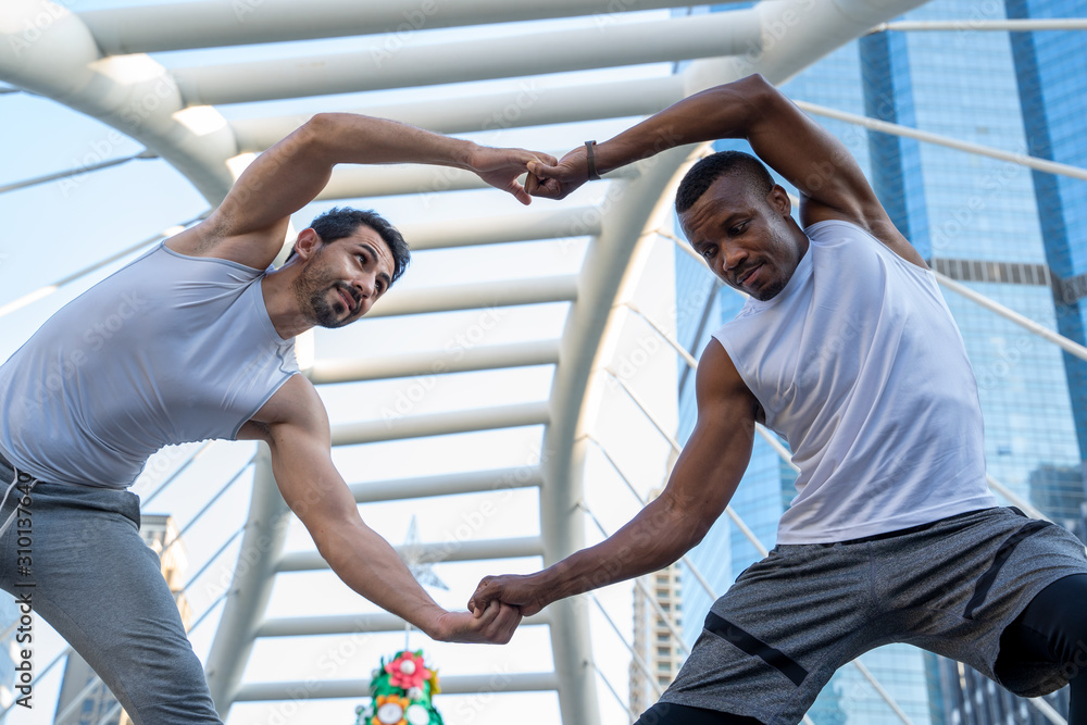 Portrait of young attractive happy fitness at city.Two man exercising together in morning.