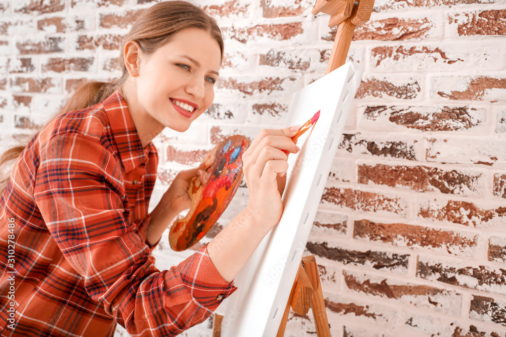 Young female artist against brick wall