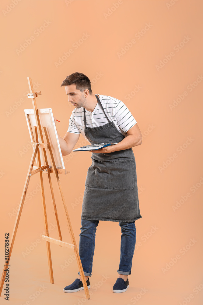 Young male artist on color background