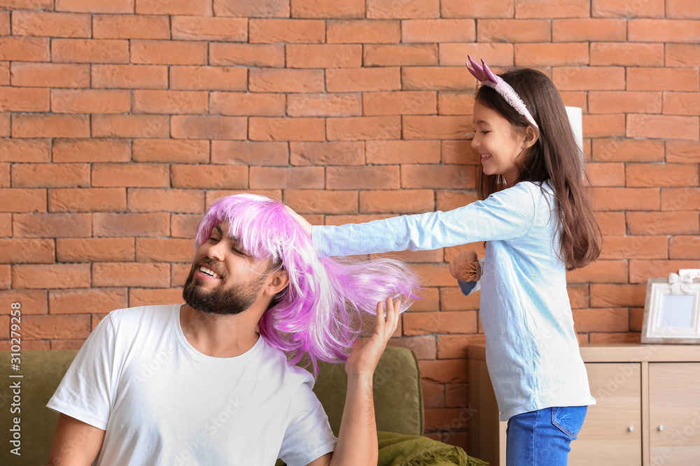 Father with little daughter having fun at home