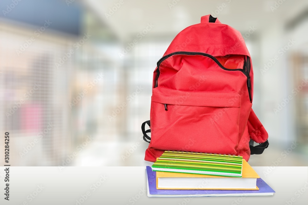 Classic school backpack and books on background.