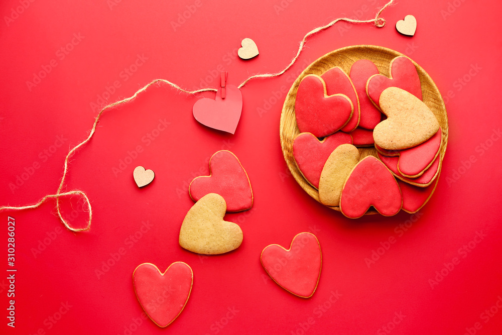 Plate with heart shaped cookies for Valentines day on color background