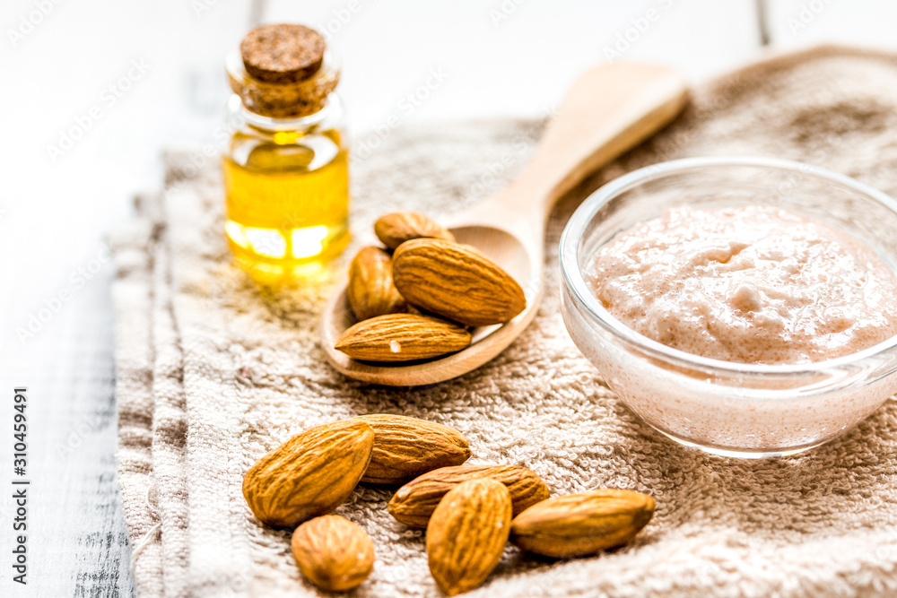 natural scrub with almond oil and towel on light table background