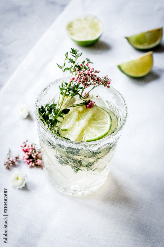 fresh homemade drink with flowers and lime on kitchen background