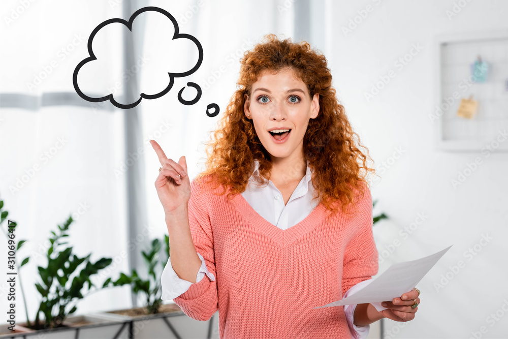 attractive and shocked businesswoman showing idea sign and holding paper near empty thought bubble i