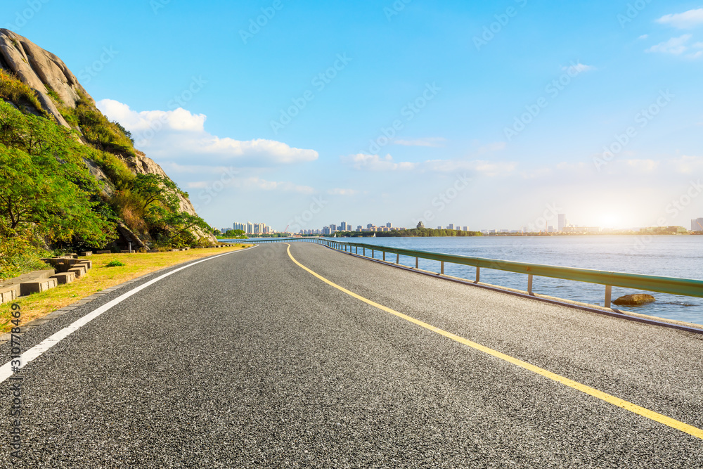 日落时分白云密布的柏油路和城市天际线。