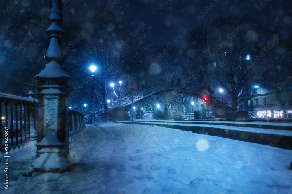 夜间降雪期间圣马丁运河上的桥梁