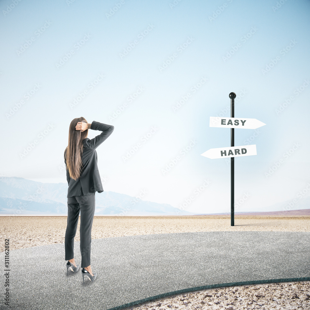 Businesswoman looking on easy and hard sign post