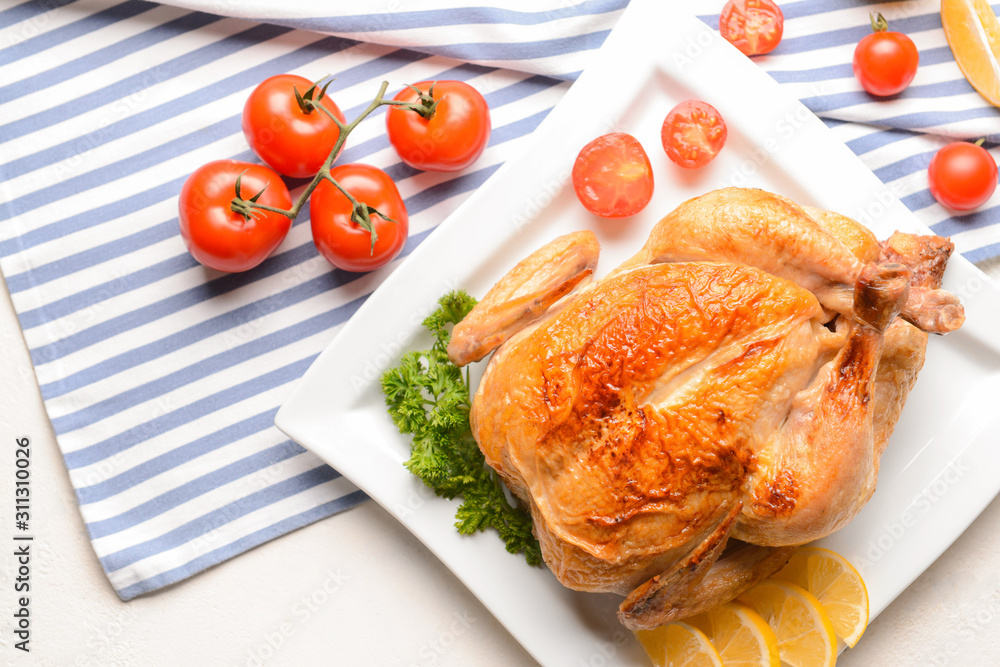 Plate with baked chicken on white background