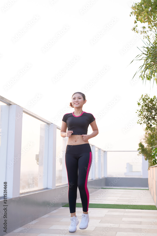 健身女士，她正在路上跑步。