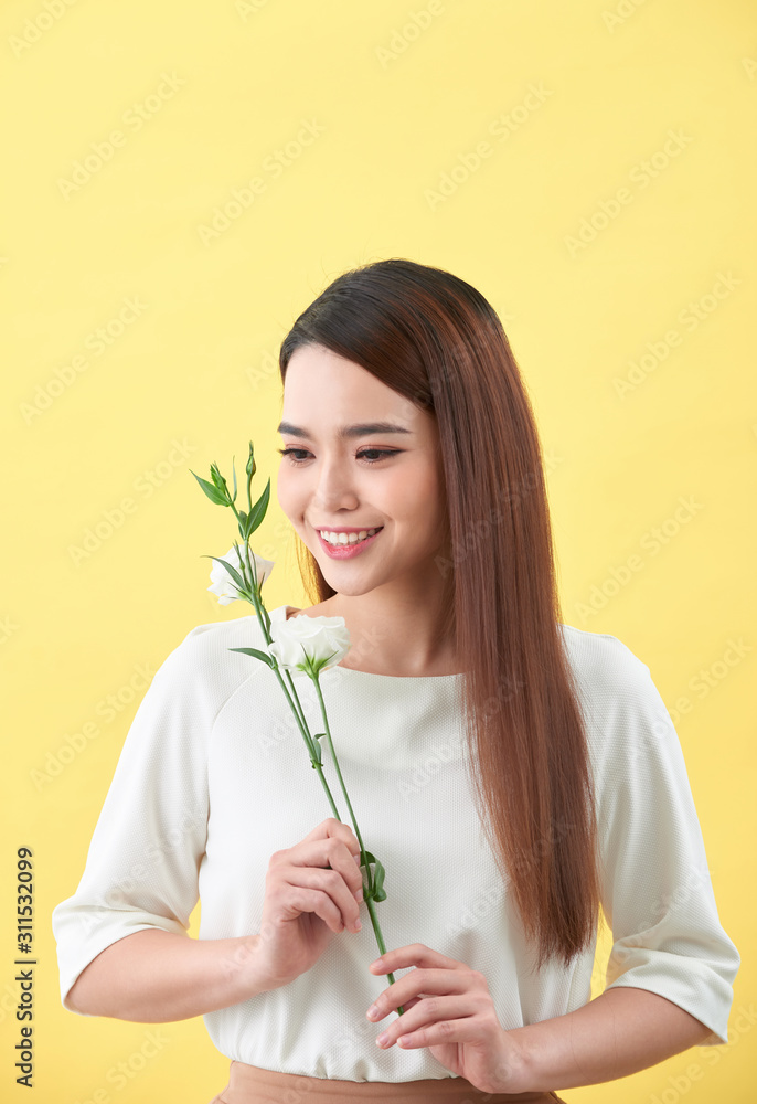 一位手持鲜花的迷人年轻女子的特写肖像