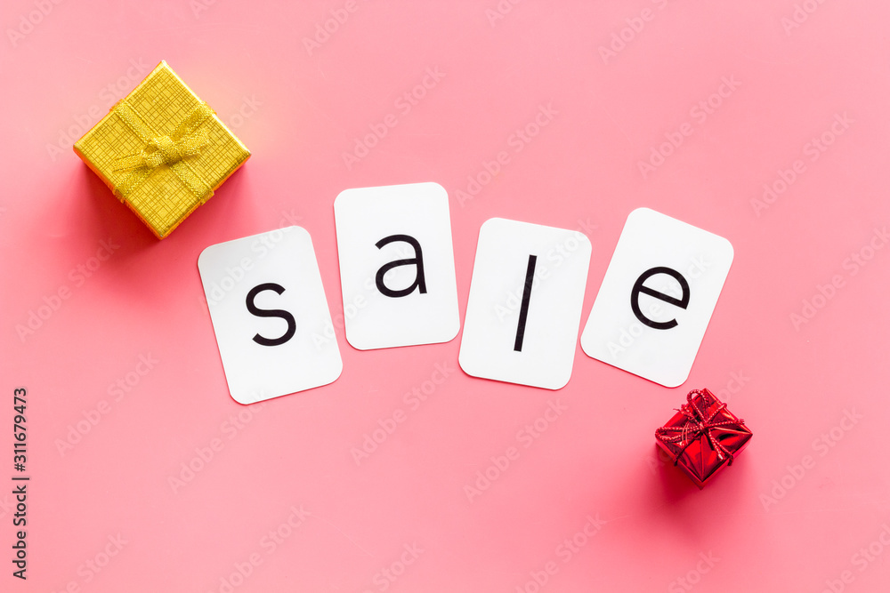 Sales message. Text Sale near gift boxes on pink background top-down copy space