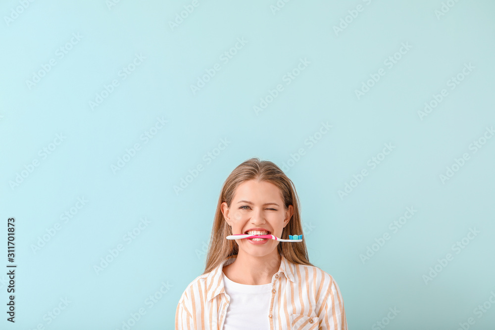 Young woman with toothbrush on color background