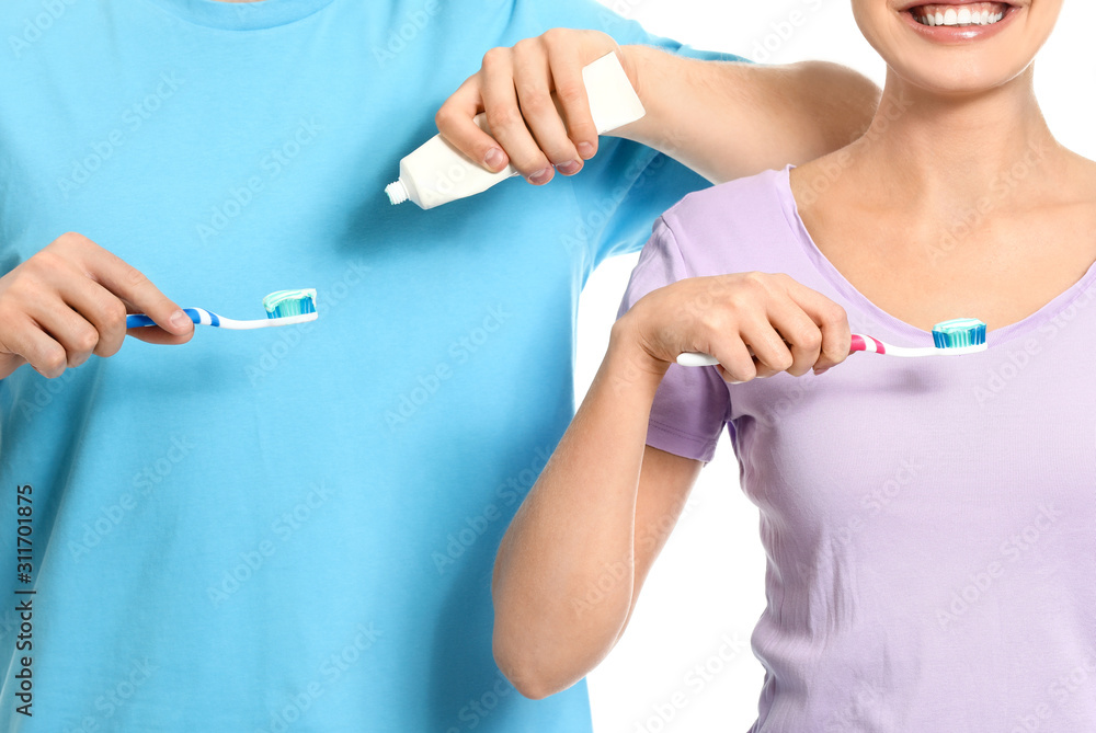 Young couple brushing teeth on white background