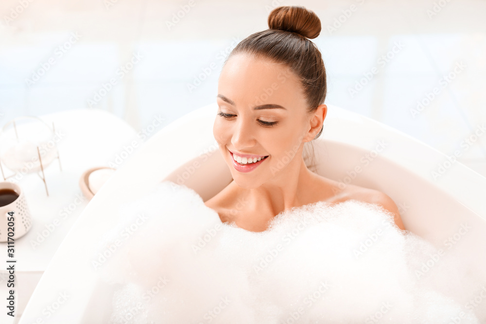 Beautiful young woman relaxing in bathtub