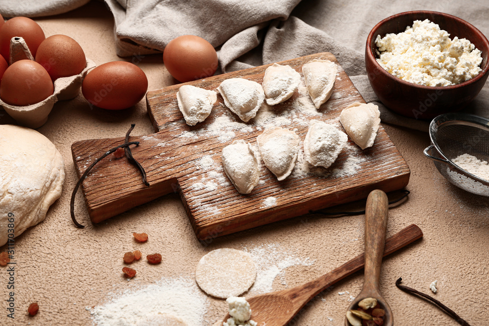 Raw dumplings and ingredients on color background