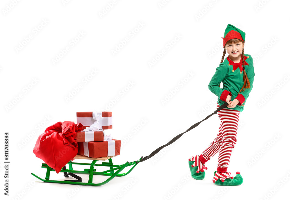 Little girl in costume of elf and with gifts on sledge against white background