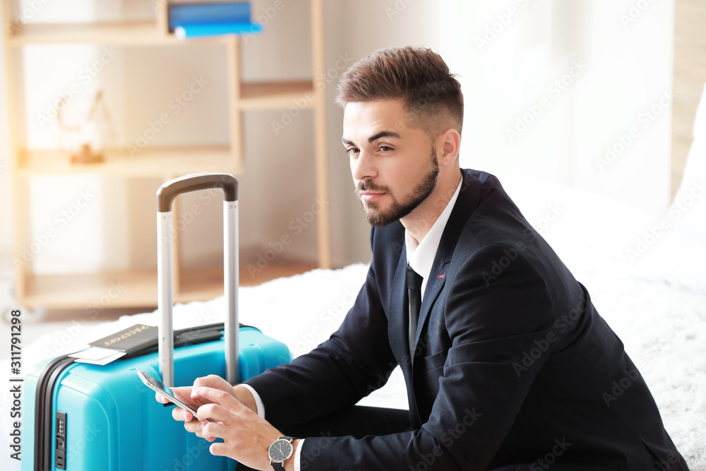 Young man with luggage for business trip at home