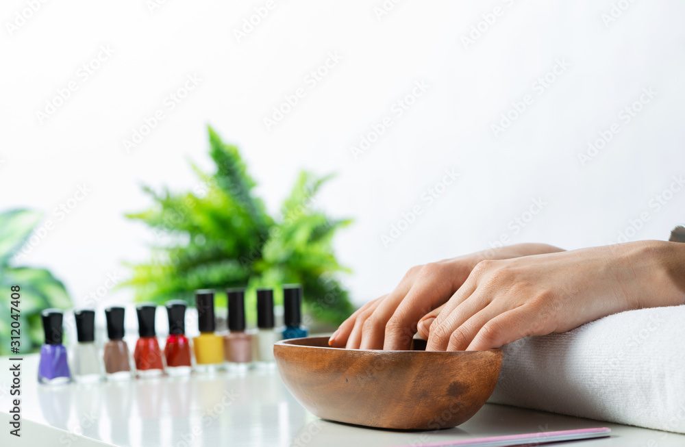 Closeup female hands in wooden bowl with water