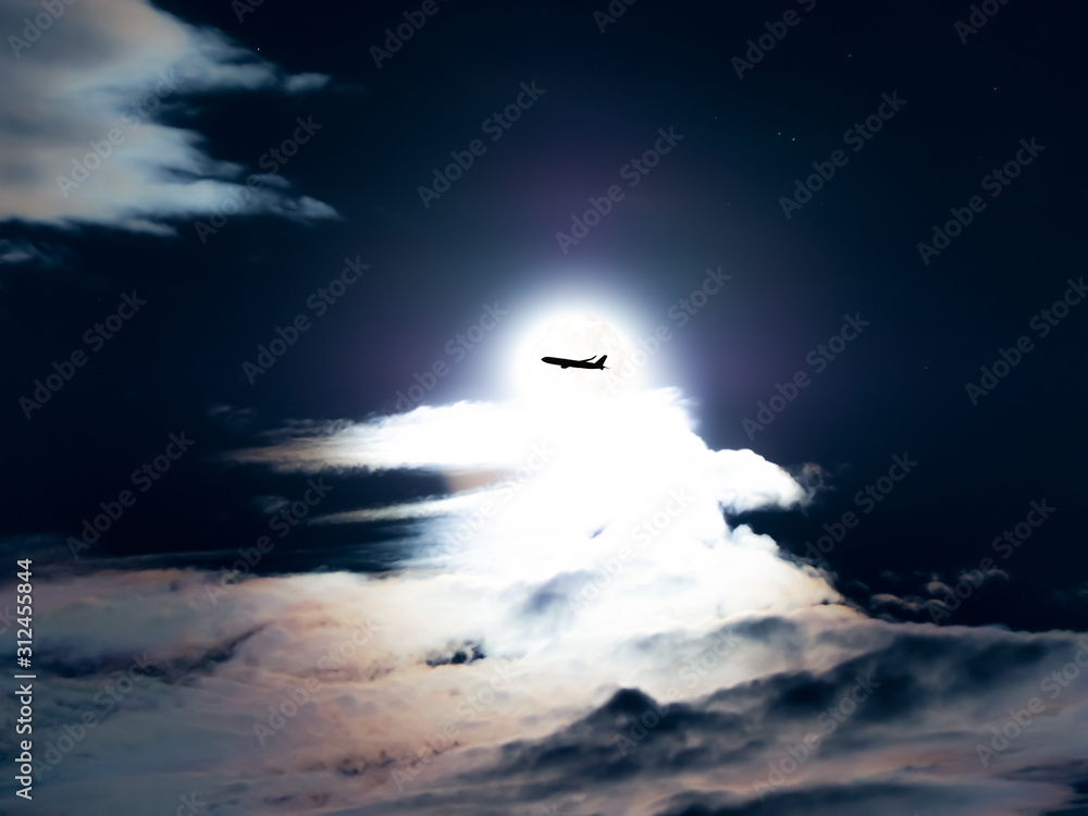 aircraft flying cross the moon in cloudy sky