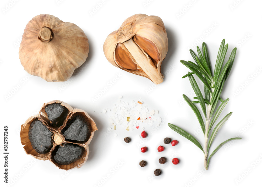 Black garlic, herbs and spices on white background