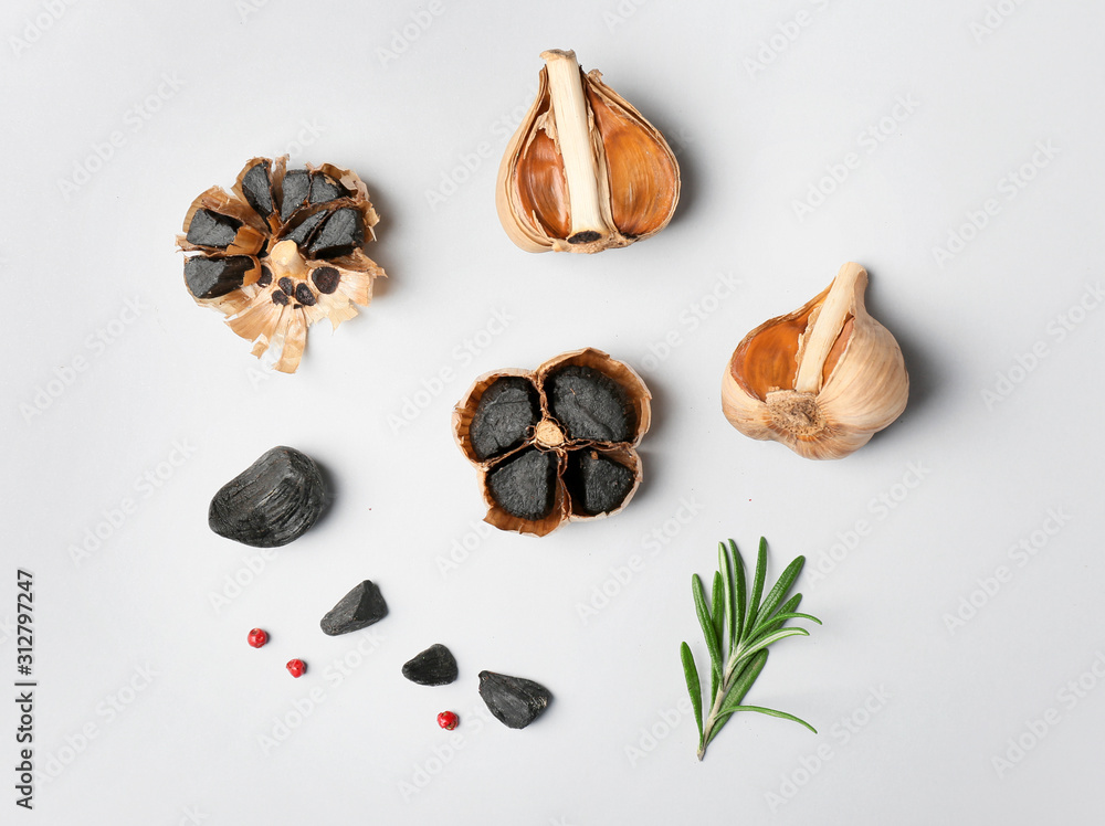 Black garlic and rosemary on white background