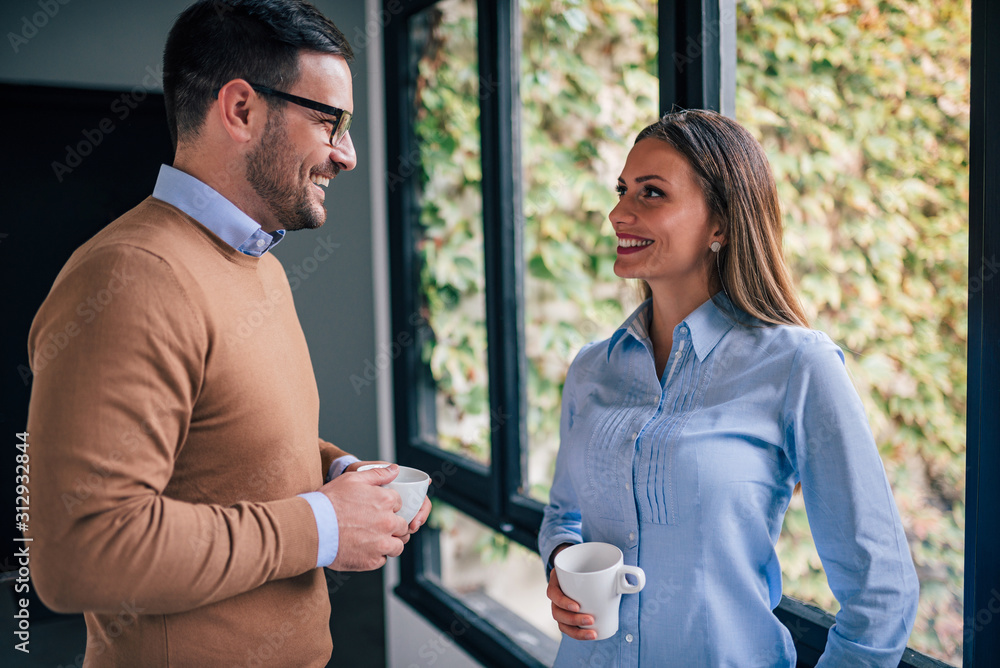 Portrait of two happy business people indoors, spending nice coffee break.