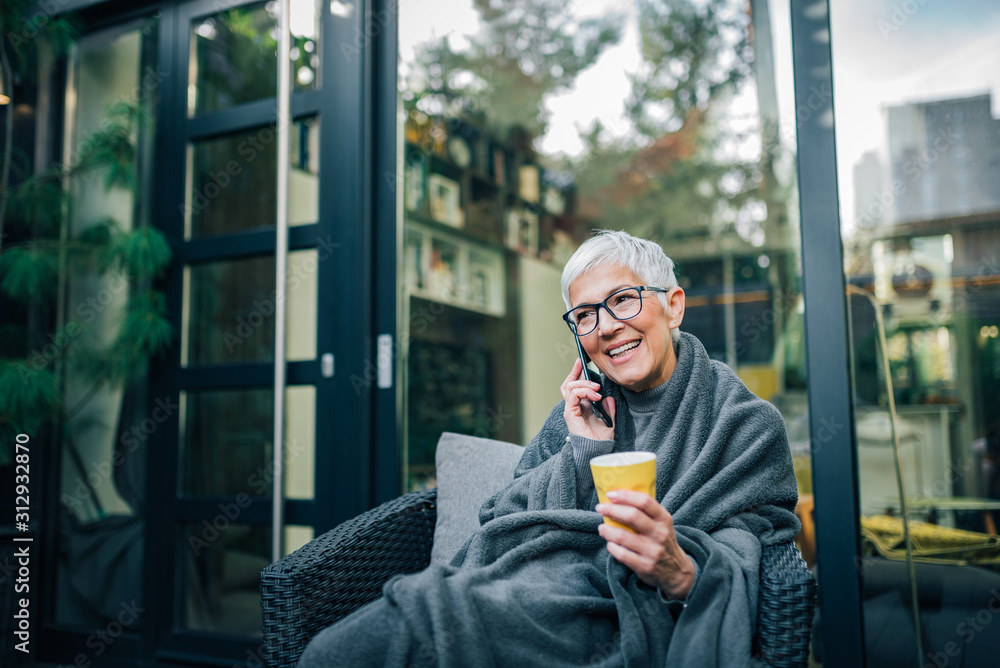 Positive senior short haired woman talking on mobile phone, portrait.