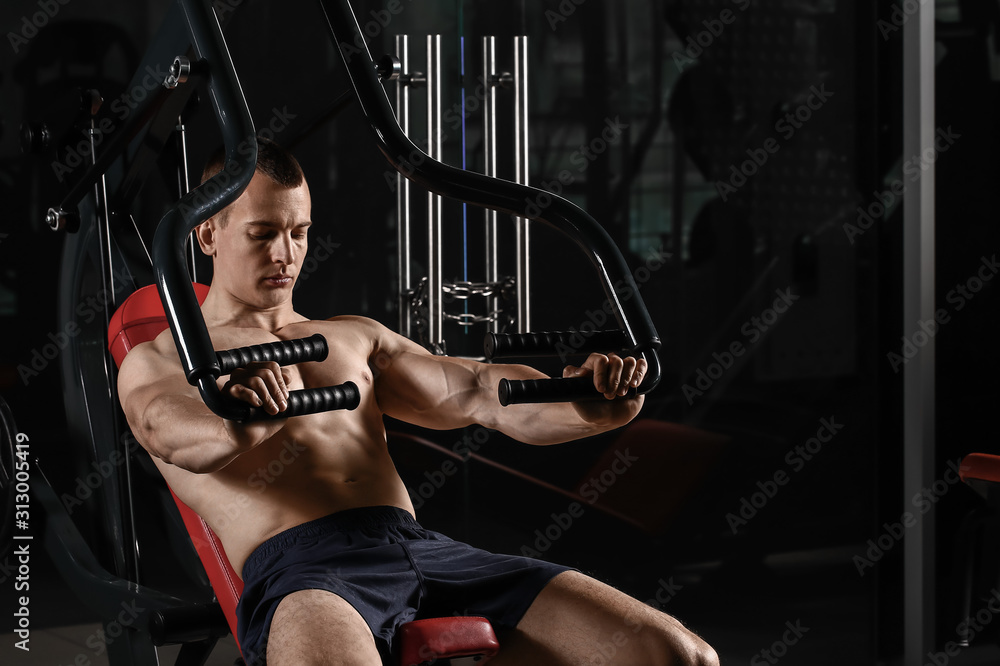 Sporty muscular man training in gym