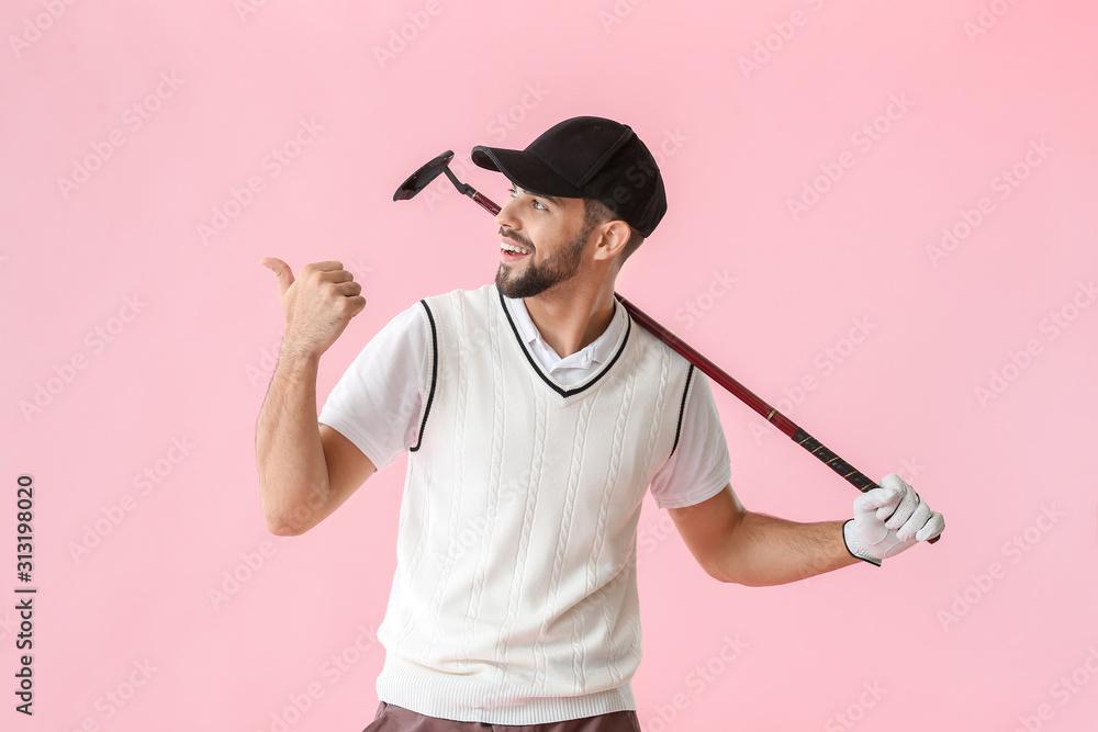 Handsome male golfer pointing at something on color background