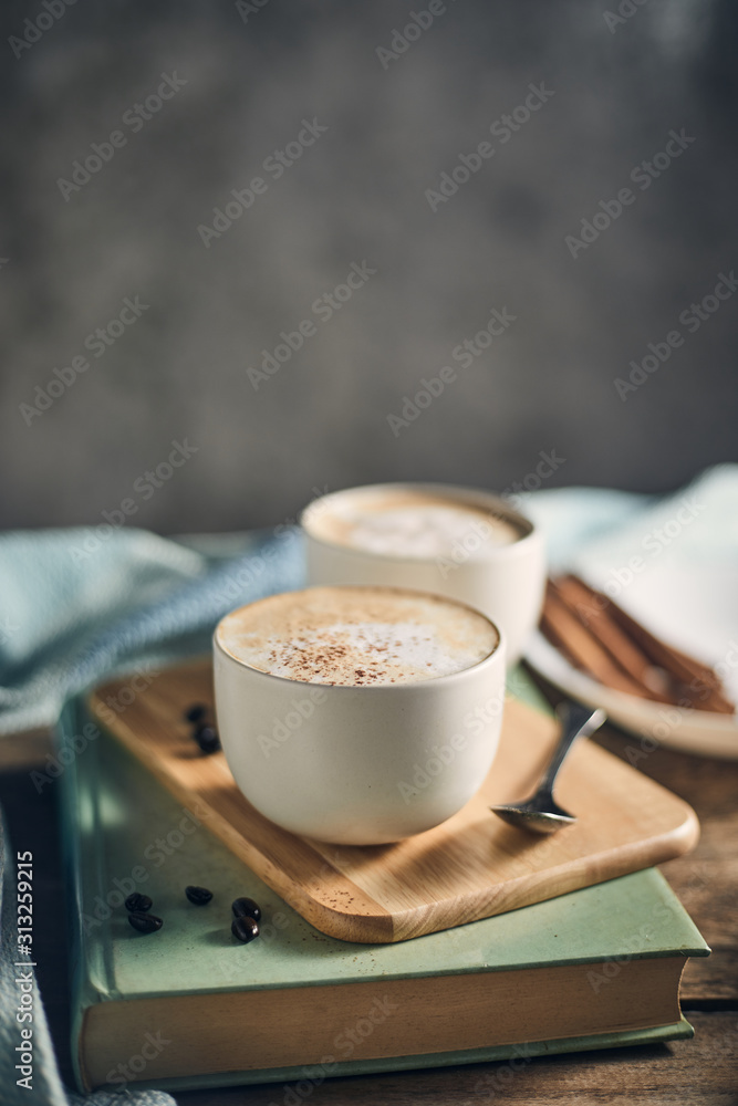 木制桌子上的热咖啡杯和咖啡豆。