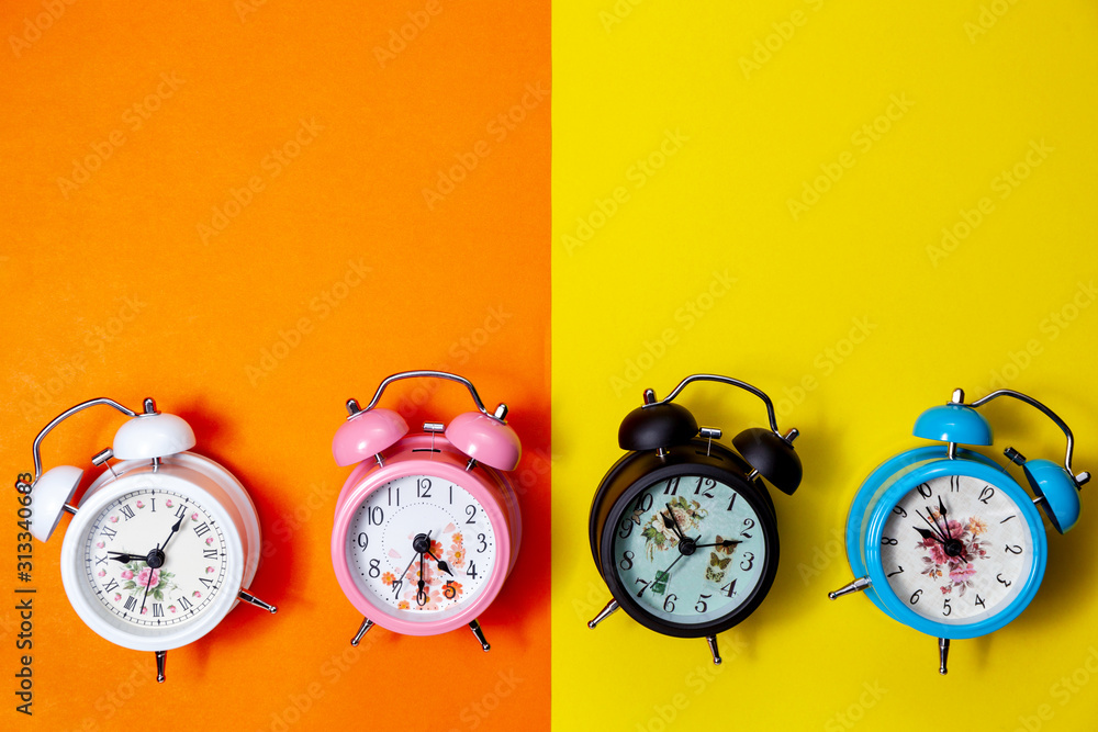 Flat lay retro beautiful new alarm clock on sweet colorful paper pastel color background.