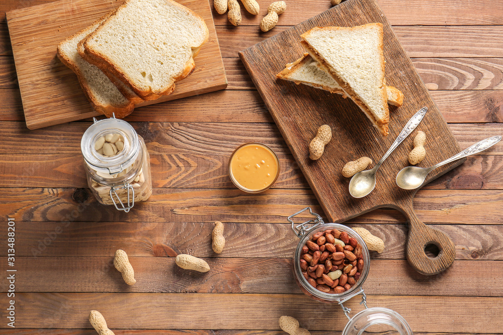 Fresh bread with tasty peanut butter on wooden table