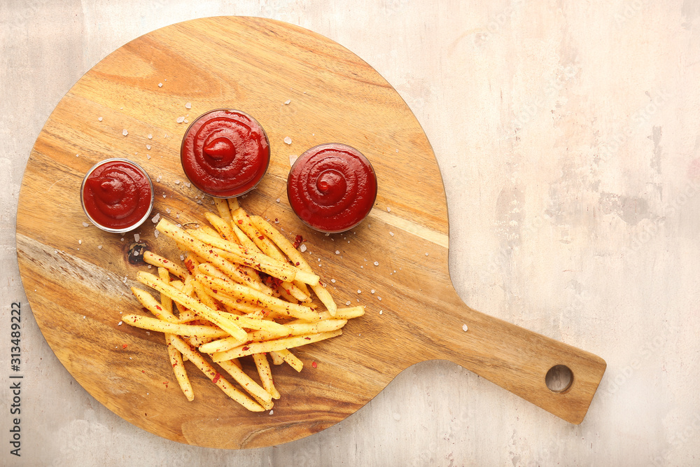 Tasty french fries and tomato sauce on grey background