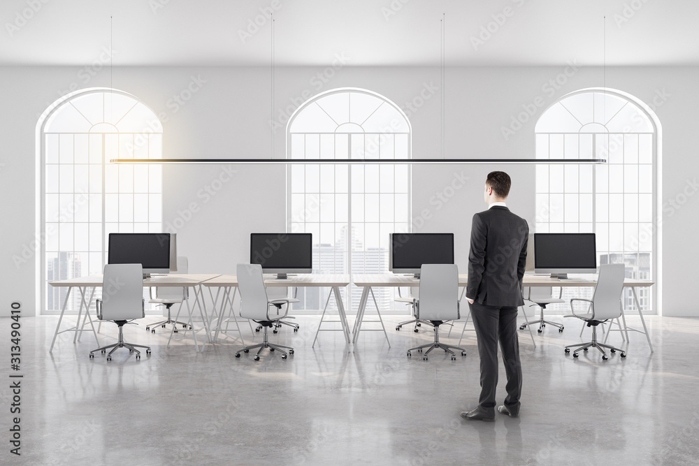 Young businessman standing in coworking office