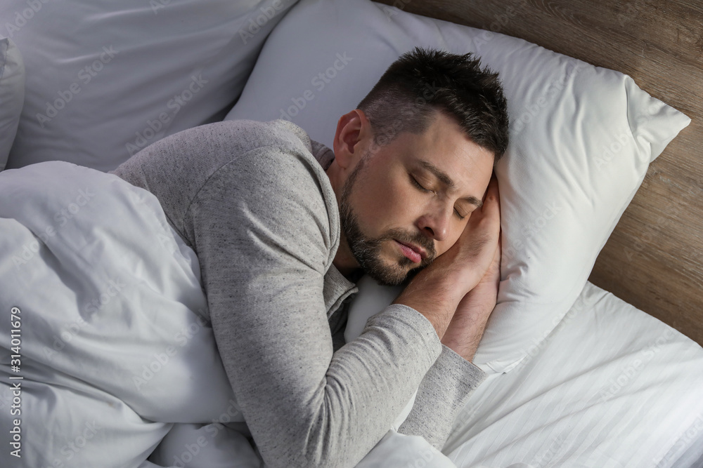 Handsome man sleeping in bed at night