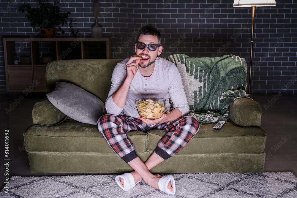 Man watching movie late in evening at home