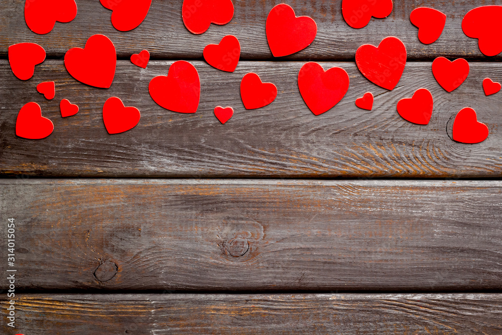 Valentines Day design. Red hearts frame on dark wooden background top-down copy space