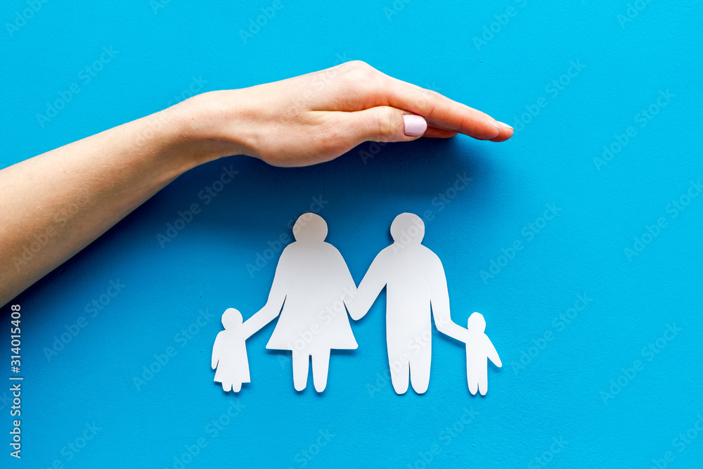 Health insurance concept. Family cutout under palms protect on blue background top-down copy space