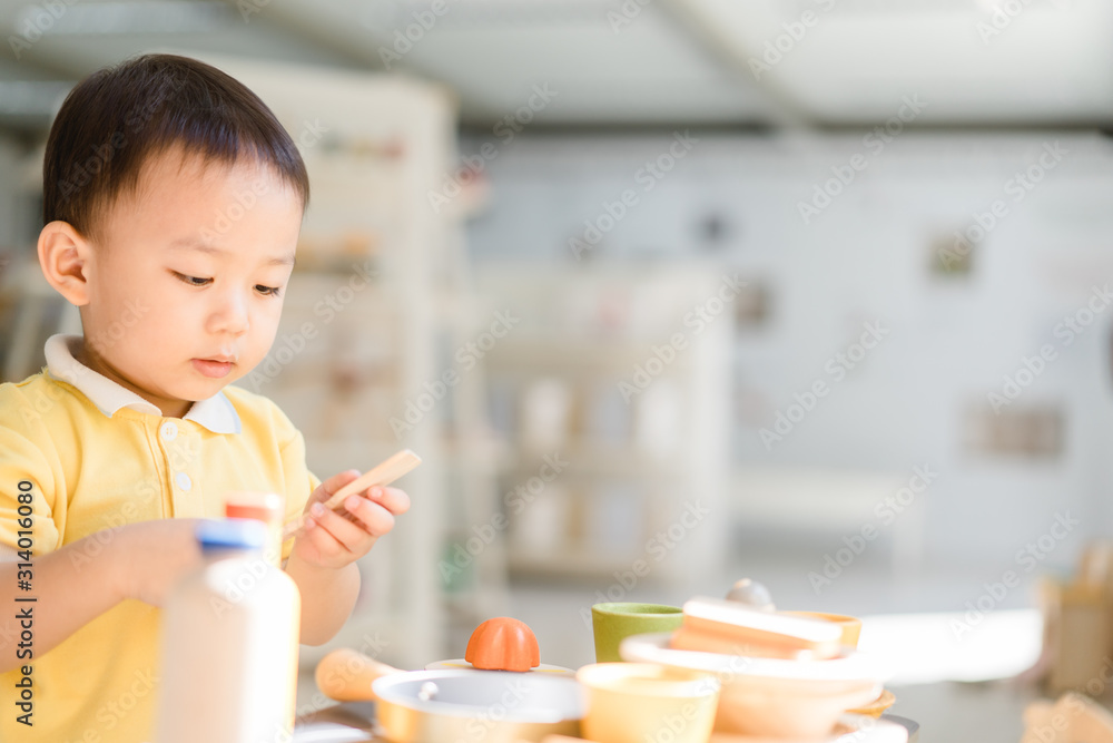 2.9 years old boy.Little child boy playing with lots of wooden toys kitchen ware like a chef.Kid pla