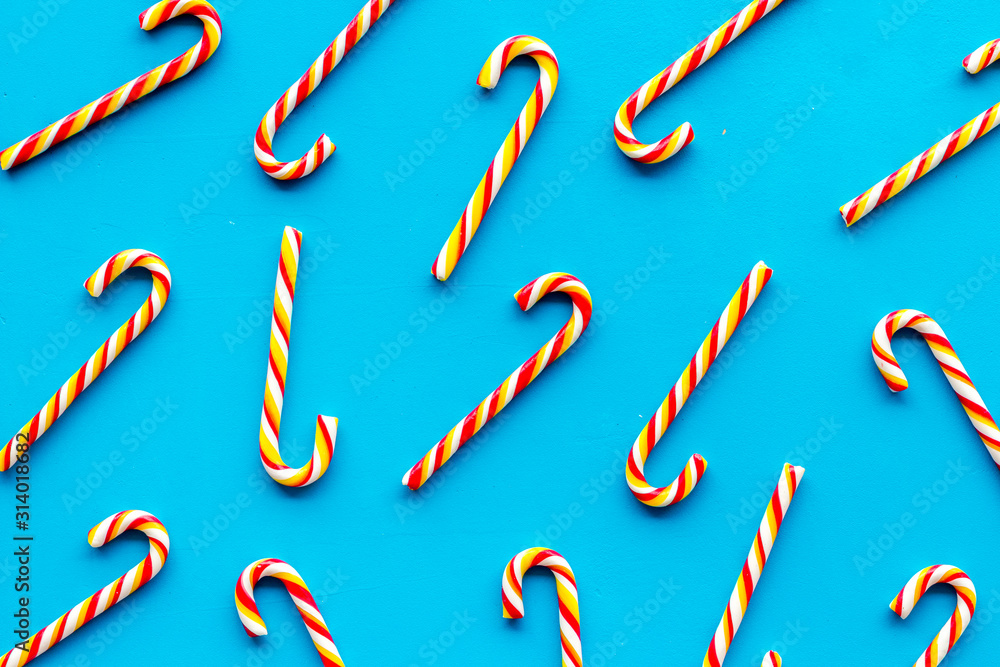 Christmas candy cane pattern on blue background top-down